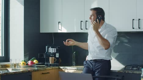 business man making coffee at luxury kitchen. man talking cellphone at kitchen.