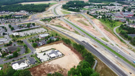 Drone-shot-of-new-bridge-construction-over-busy-highway,-wide