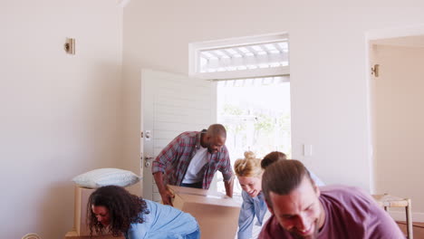 Slow-Motion-Shot-Of-Friends-Help-Couple-To-Carry-Boxes-Into-New-Home-On-Moving-Day