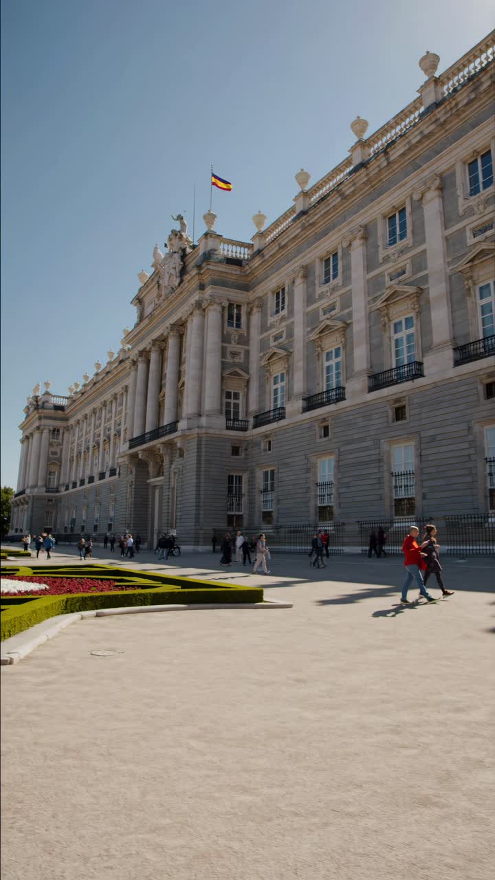 Scatto grandangolare della facciata di un grande palazzo sotto un cielo sereno, che cattura la sua eleganza architettonica