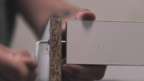 assembly wooden furniture at home using screw allen. fixing chipboard parts with a hexagon