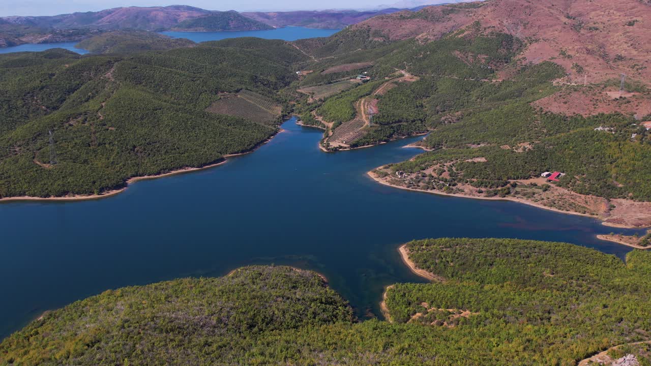 북부 알바니아의 산악 호수, 무성한 초목과 푸른 하늘을 반영하는 잔잔한 물
