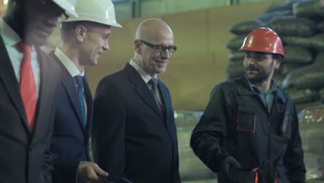 businessmen and workers discussing in a warehouse