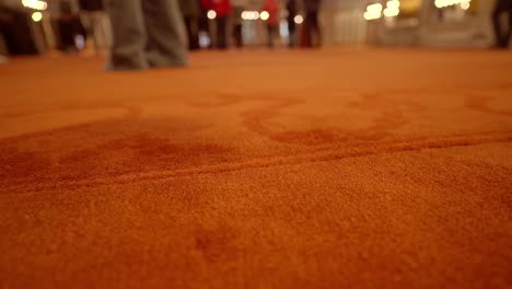 close up of a red carpet in a room with people