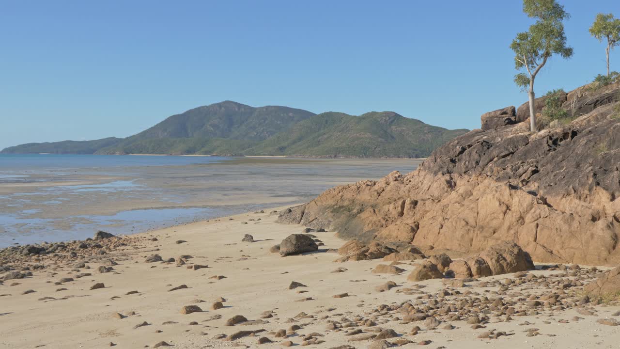 rocas de playa en la costa arenosa de la isla shaw durante la marea baja en whitsundays, queensland, australia del norte