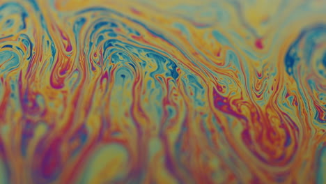 psychedelic macro shot of a viscous rainbow colored liquid