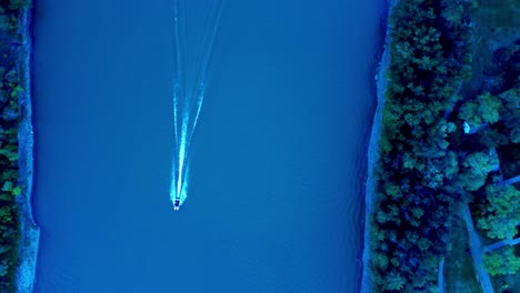 Summer-aerial-birds-eye-view-flyover-zoom-out-of-speed-boat-passes-by-making-white-caps-down-the-river-from-East-to-West-in-between-the-Kinsmen-Park-and-Victoria-Park-on-a-twilight-in-Edmonton-2-2