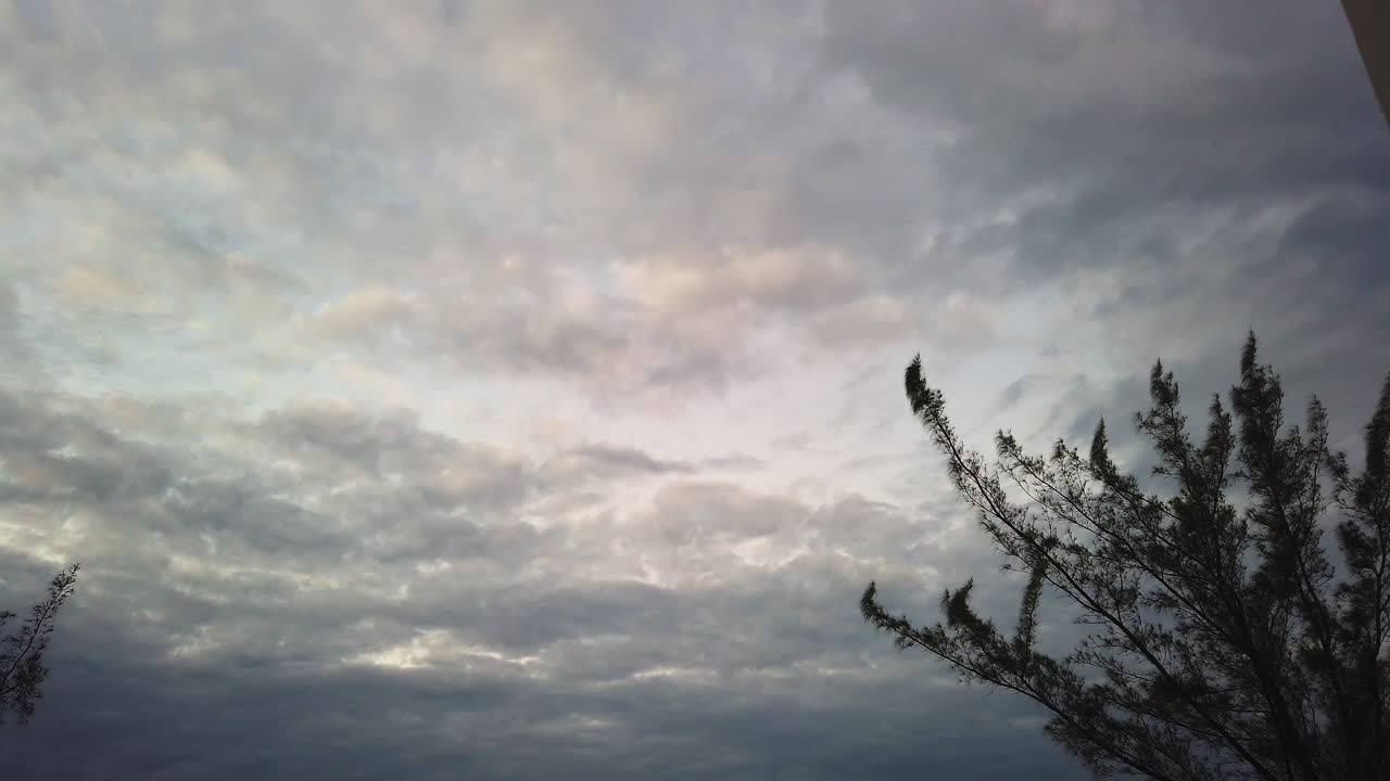 모션 스 (motionlapse) 는 자메이카 해안가에서 조용한 해가 지는 동안 활기찬 구름에서 아래로 기울어져 방문객들이 해변을 따라 고 있습니다.