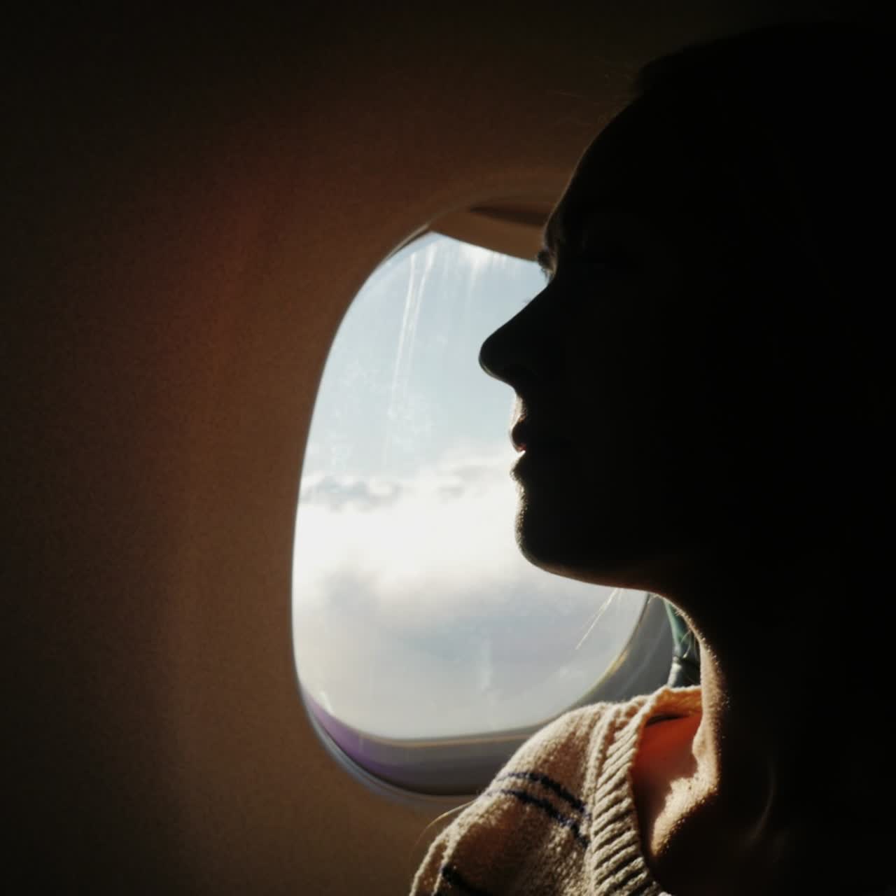 한 여성 승객이 비행기 창밖으로 2시 아래 도시를 내다본다