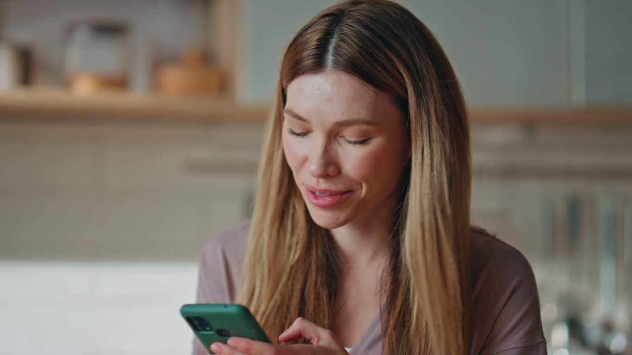 Girl messaging cell phone at home kitchen closeup. Housewife making online order