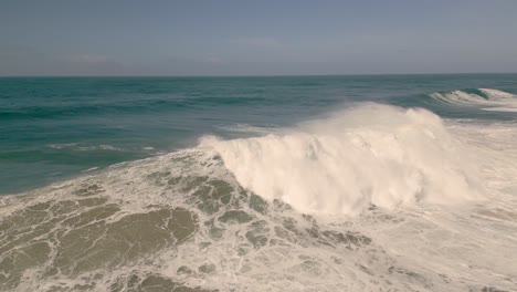 olas gigantes rompiendo en un día soleado en nazare, portugal