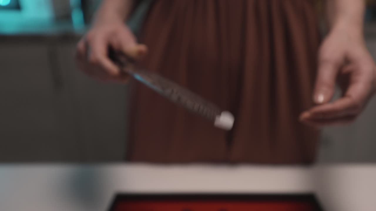 Woman holding a knife in a kitchen