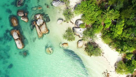 secret exotic beach through limestone cliffs alongside white sandy beach of tropical island coastline in thailand