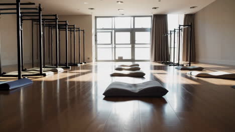 empty yoga and meditation studio with sunlight and wooden floor