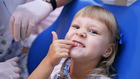 Little child in stomatology chair. Child in stomatological cabinet with dentists