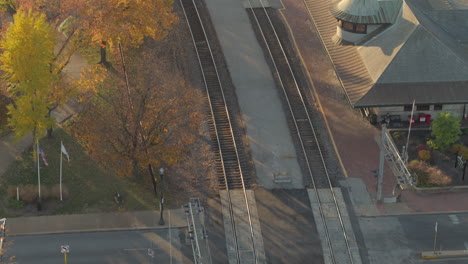 Aerial-tilt-up-over-train-tracks-and-train-station-in-Kirkwood-in-St