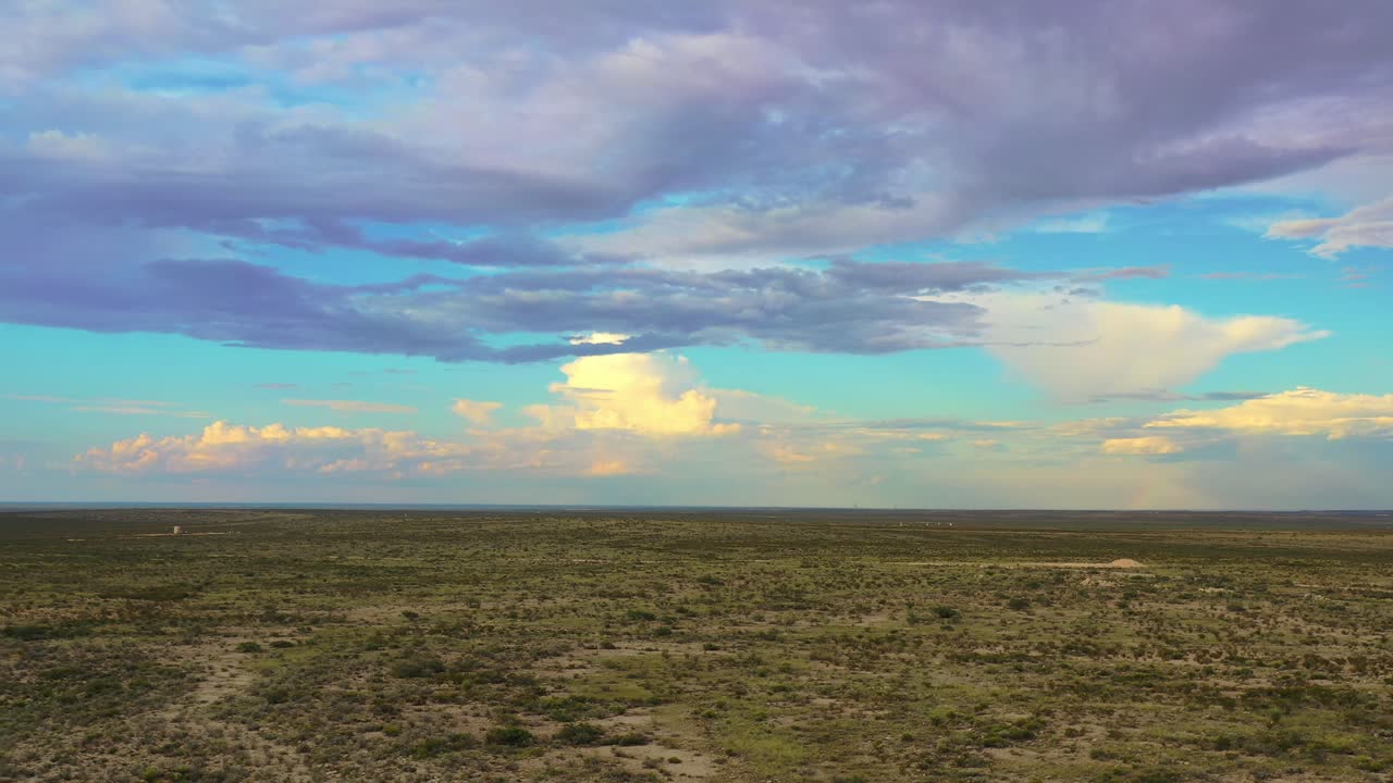drone sobre el desierto con nubes y arco iris, cepillo bajo