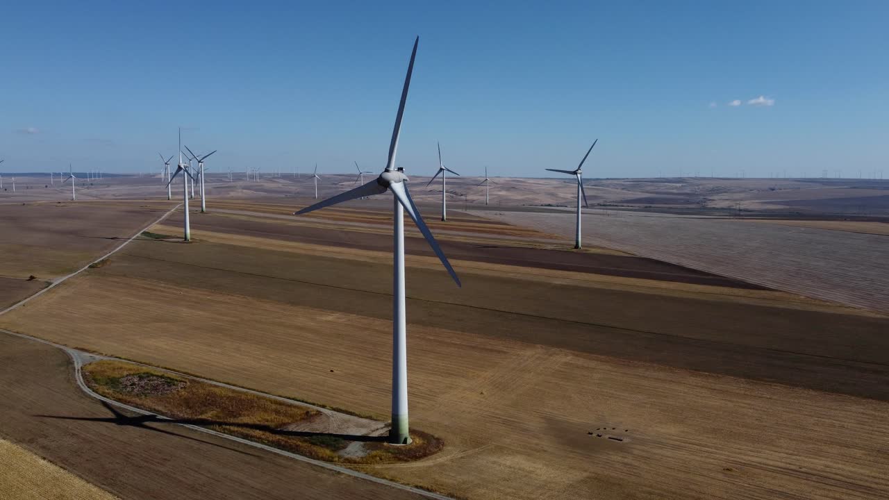 Drone flying amongst wind turbines on wind farm, Europe
