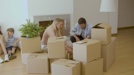 man and woman taking things out of carton boxes after moving