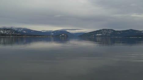 calm and nice shuswap lake near sorrento in britsh colombia on a cloudy day with the high rocky mountains on the background