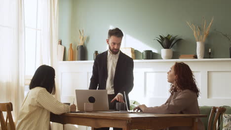 hombre de negocios debatiendo con dos colegas mujeres durante una reunión de equipo