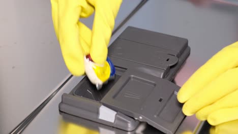 closeup of a woman putting a tablet of dishwasher detergent into a box