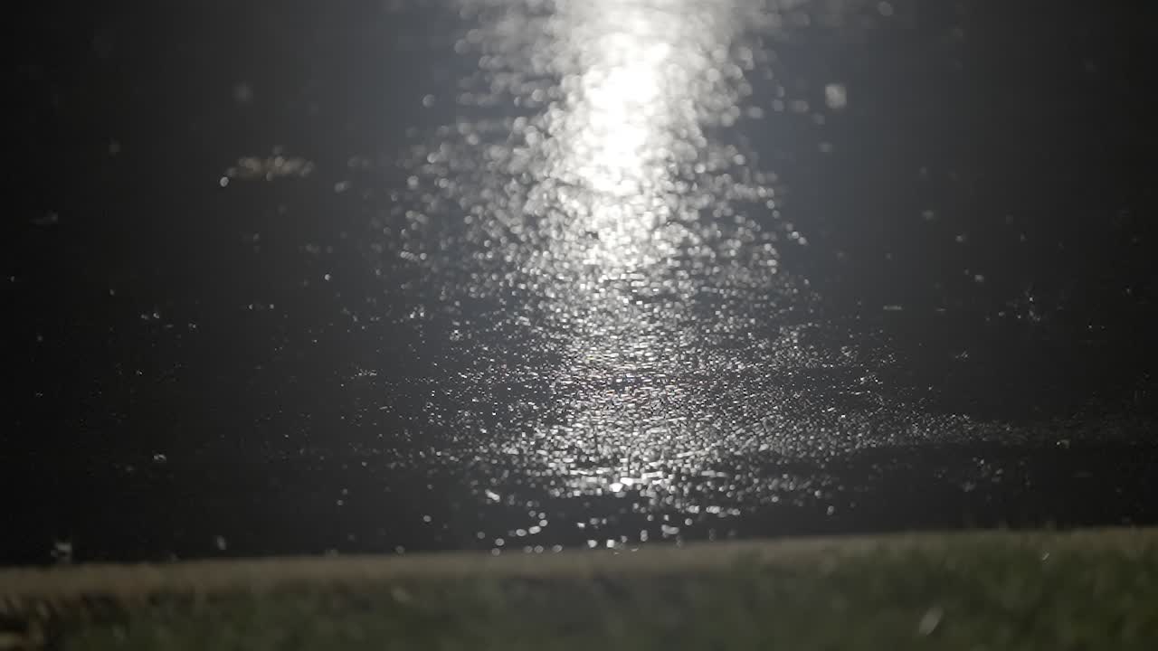 Dark City Street During Rainfall with Streetlight Reflection
