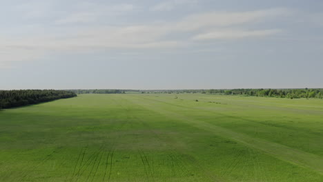 point of view aerial camera rising high above a panoramic grass field