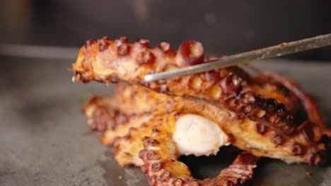 Pulpo-Dorado-Crujiente-Perfectamente-Sellado,-El-Chef-Transfiere-El-Tentáculo-Cortado-A-Un-Lado-Antes-De-Emplatar