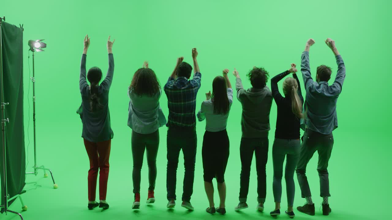 그린 스크린 크로마 키 스튜디오: 대중 스포츠 행사, 콘서트, 페스티벌, 파티에서 다민족 팬들의 다양한 군중이 환호하고, 뛰어내리고, 공중에서 손을 들어 박수를 치고 있습니다.