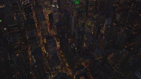 High-angle-view-of-night-city.-Tilt-up-reveal-of-cityscape-with-high-rise-buildings.-Manhattan,-New-York-City,-USA