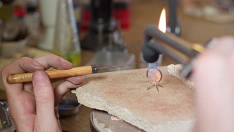 gold wedding ring getting crafted with fire by jeweller