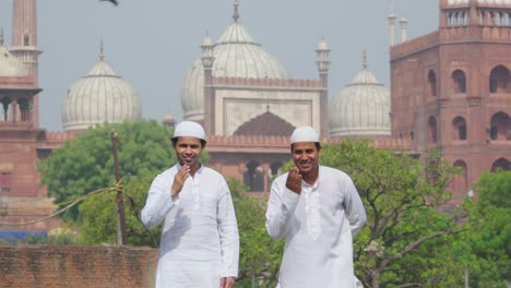 Muslimische-Freunde-Blicken-In-Richtung-Kamera,-Während-Sie-Vor-Der-Jama-Masjid-Delhi-Stehen