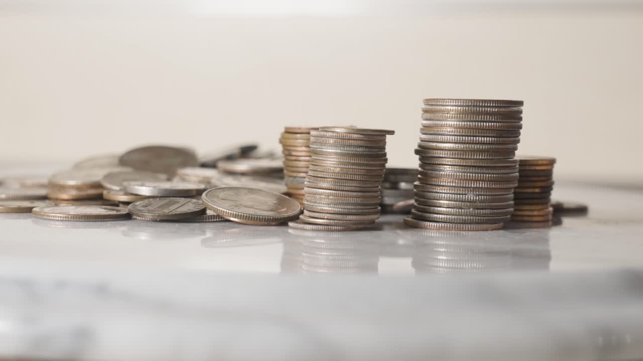 Pilhas de moedas americanas empilhadas girando sobre uma mesa.