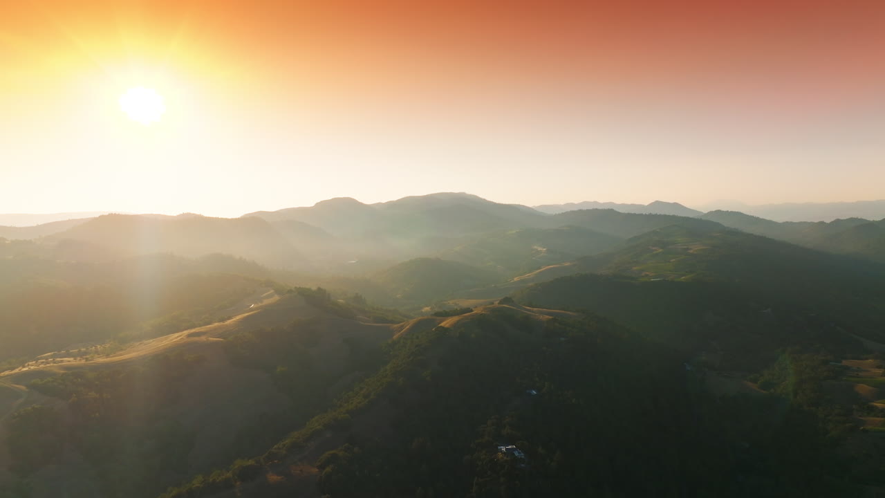 Beautiful green hills covered with vineyards. Picturesque rocky landscape in the rays of setting sun. Pink sky at backdrop.