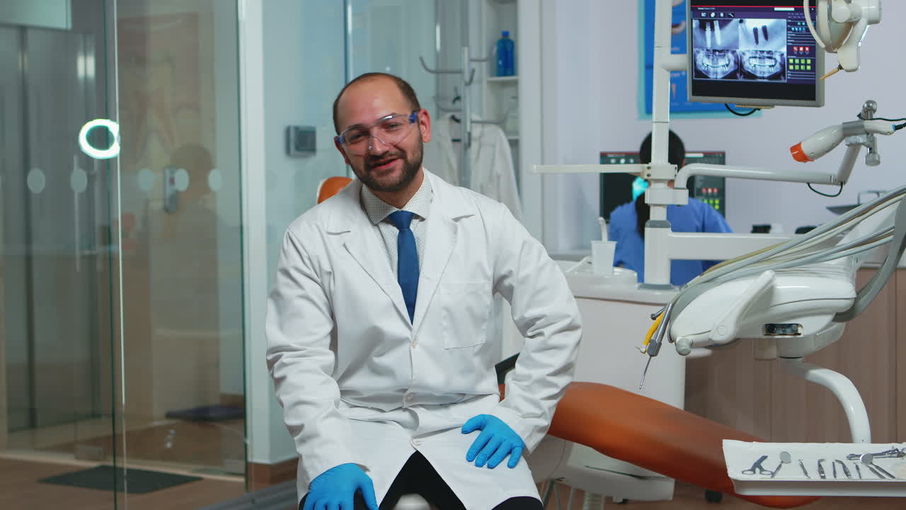 Dottore dentista che guarda la telecamera e parla con i pazienti