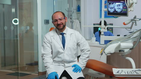 el dentista mirando a la cámara hablando con los pacientes