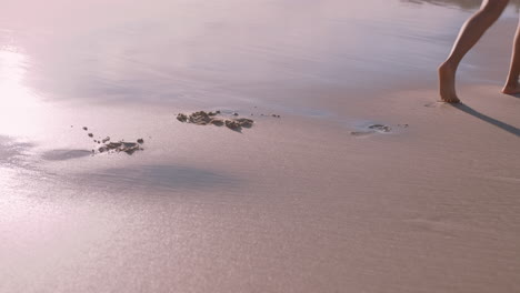 close up woman feet walking barefoot on beach at sunset leaving footprints in sand female tourist on summer vacation