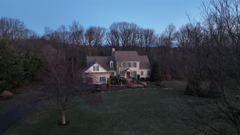 villa with parking car in rural suburb area of american town at dawn. leafless trees in garden on frozen early morning in winter.