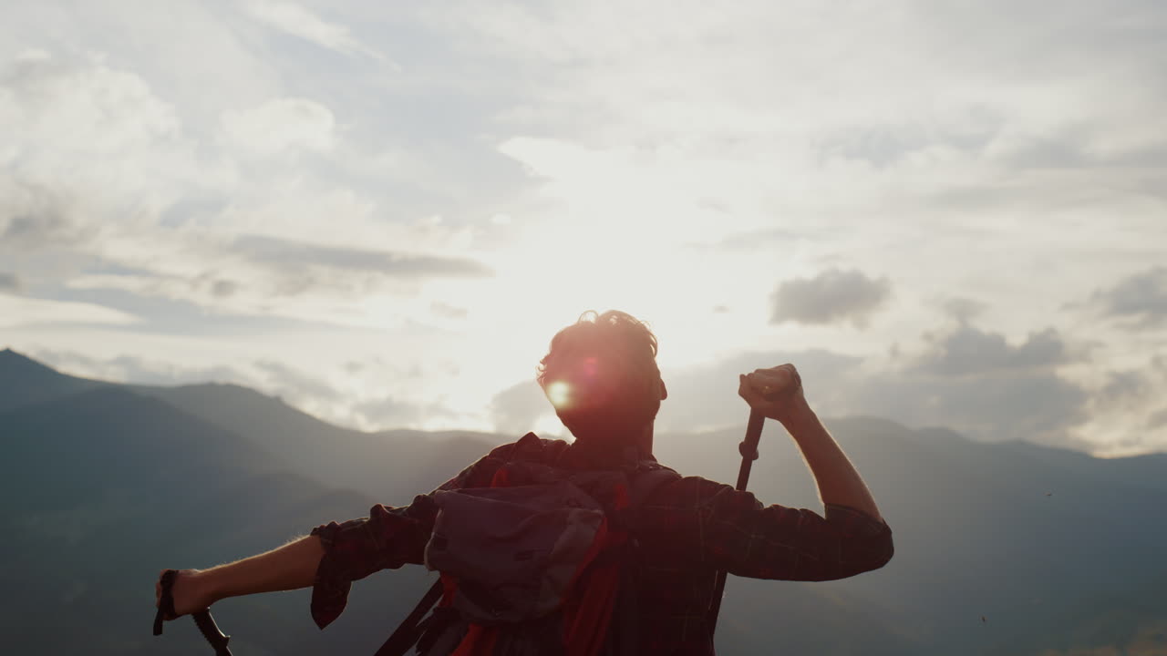 una caminata exitosa por las montañas al atardecer. un turista celebra el viaje.