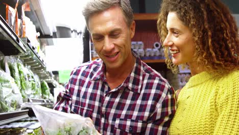 Happy-couple-selecting-vegetables-in-organic-section-of-supermarket