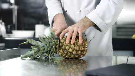 el chef cortando piña en cámara lenta, el hombre cortando fruta fresca.