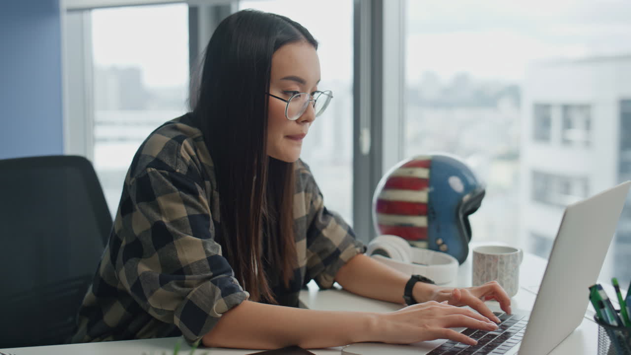 chica involucrada escribiendo en el teclado de la oficina panorámica. mujer escribiendo texto en la computadora portátil