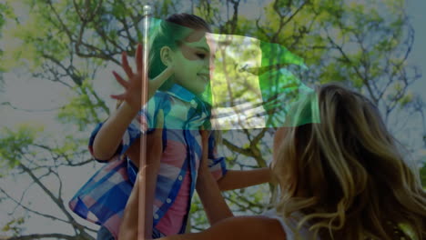 child being lifted by adult over waving flag animation and tree background