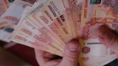 men's hands demonstrate russian money spreading them out like a fan