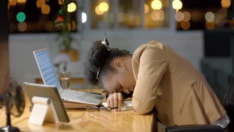 una mujer de negocios afroamericana descansa su cabeza en un escritorio por la noche, con espacio para copiar