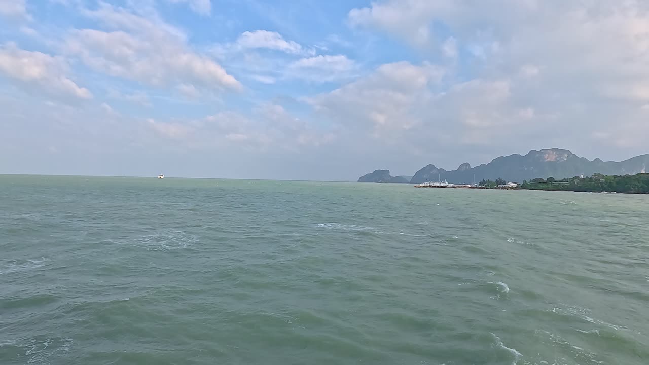 A tranquil ocean scene with distant islands under a partly cloudy sky, showcasing natural beauty and calmness