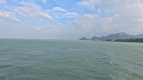 a tranquil ocean scene with distant islands under a partly cloudy sky, showcasing natural beauty and calmness