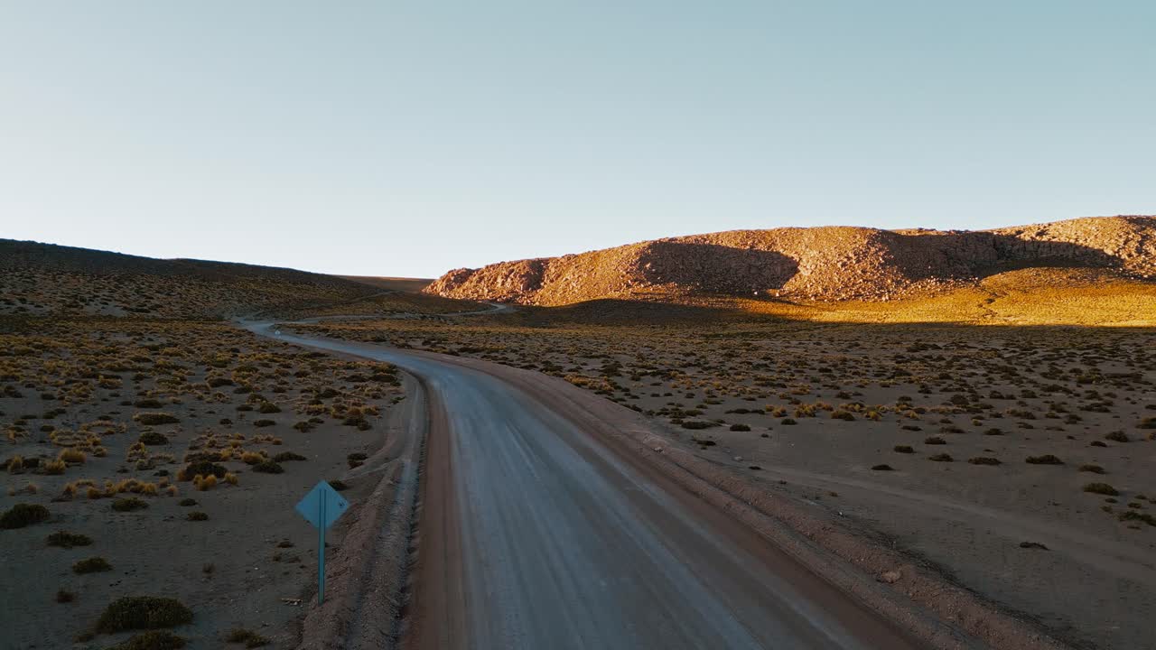 ofreciendo una perspectiva única desde arriba, las imágenes de drones muestran el impresionante desierto de atacama al amanecer, con una carretera que serpentea a través del paisaje estéril de abajo
