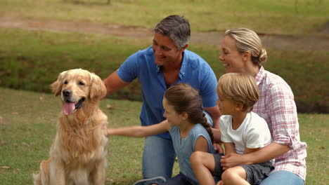 Happy-family-smiling-at-the-camera-with-their-dog